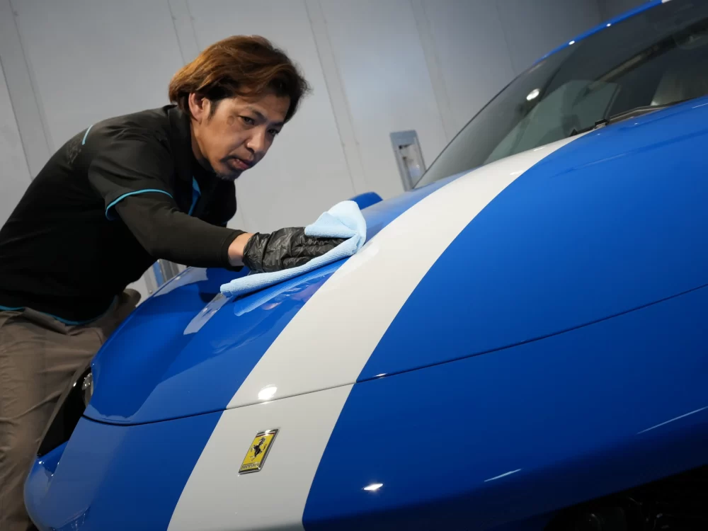 フェラーリ296のPPF施工面に塗布したHALOコーティングを拭き上げる職人 kirameki